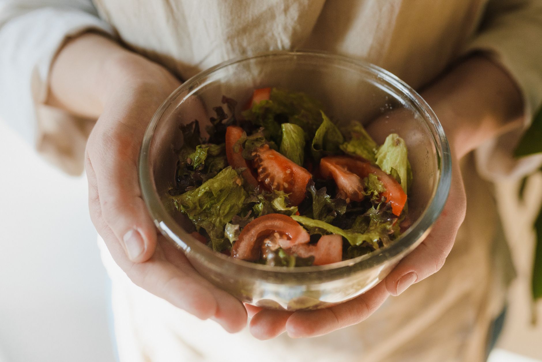 A toddler holding a bowl of healthy plant-based food.