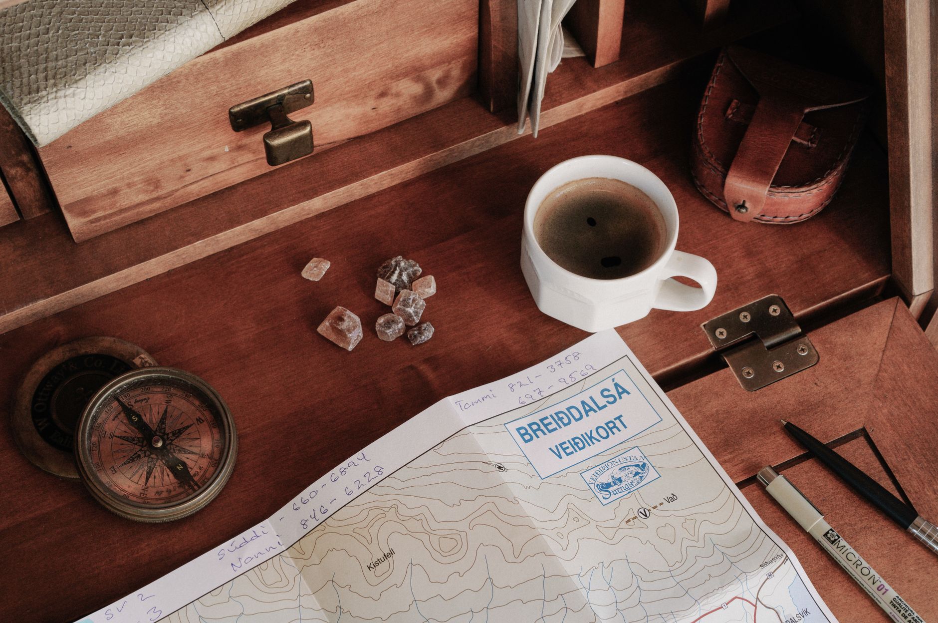 A child engaging with a compass and travel journal for an educational trip.