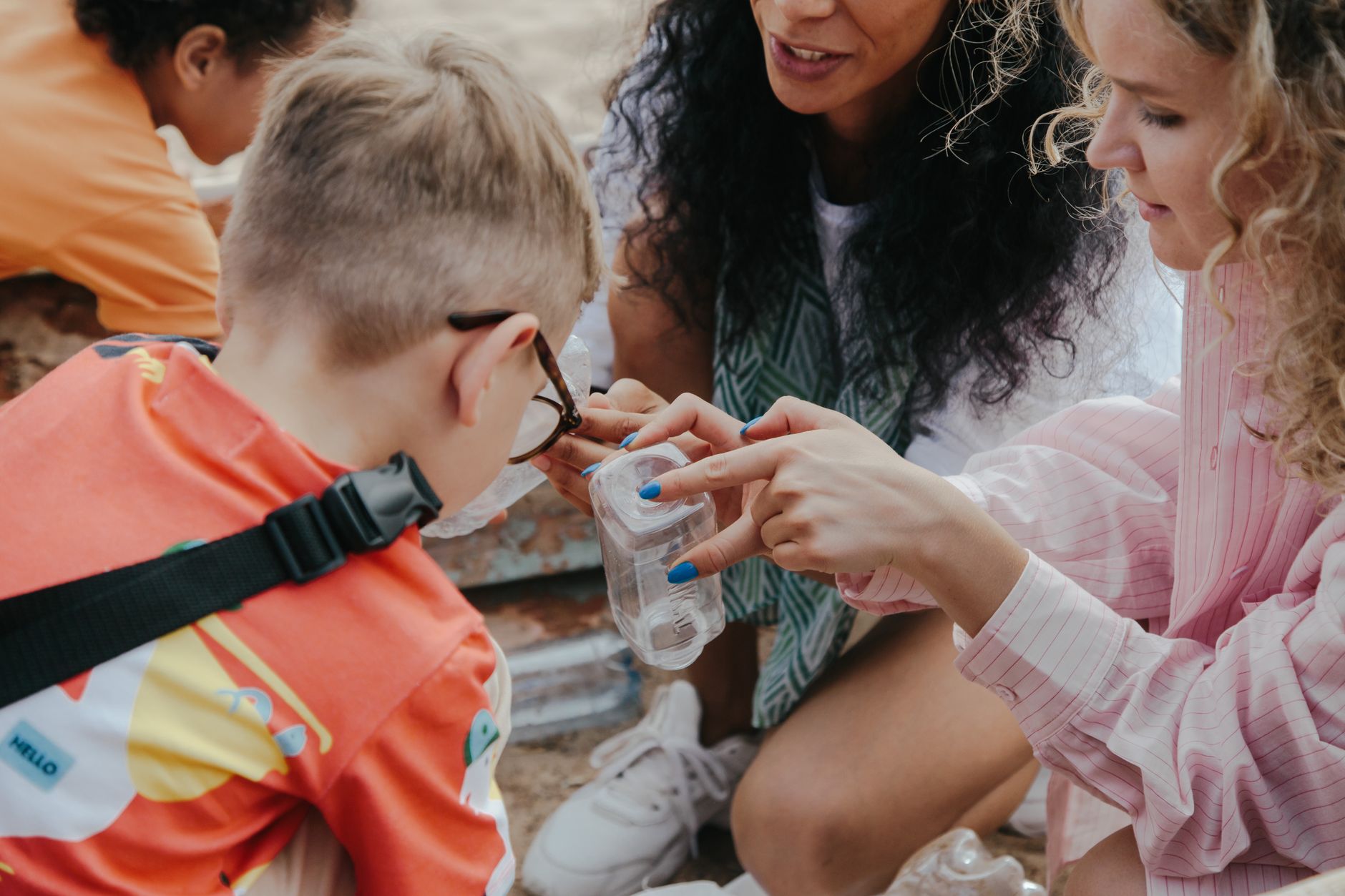 A parent teaching a child about recycling and waste management in a home setting.