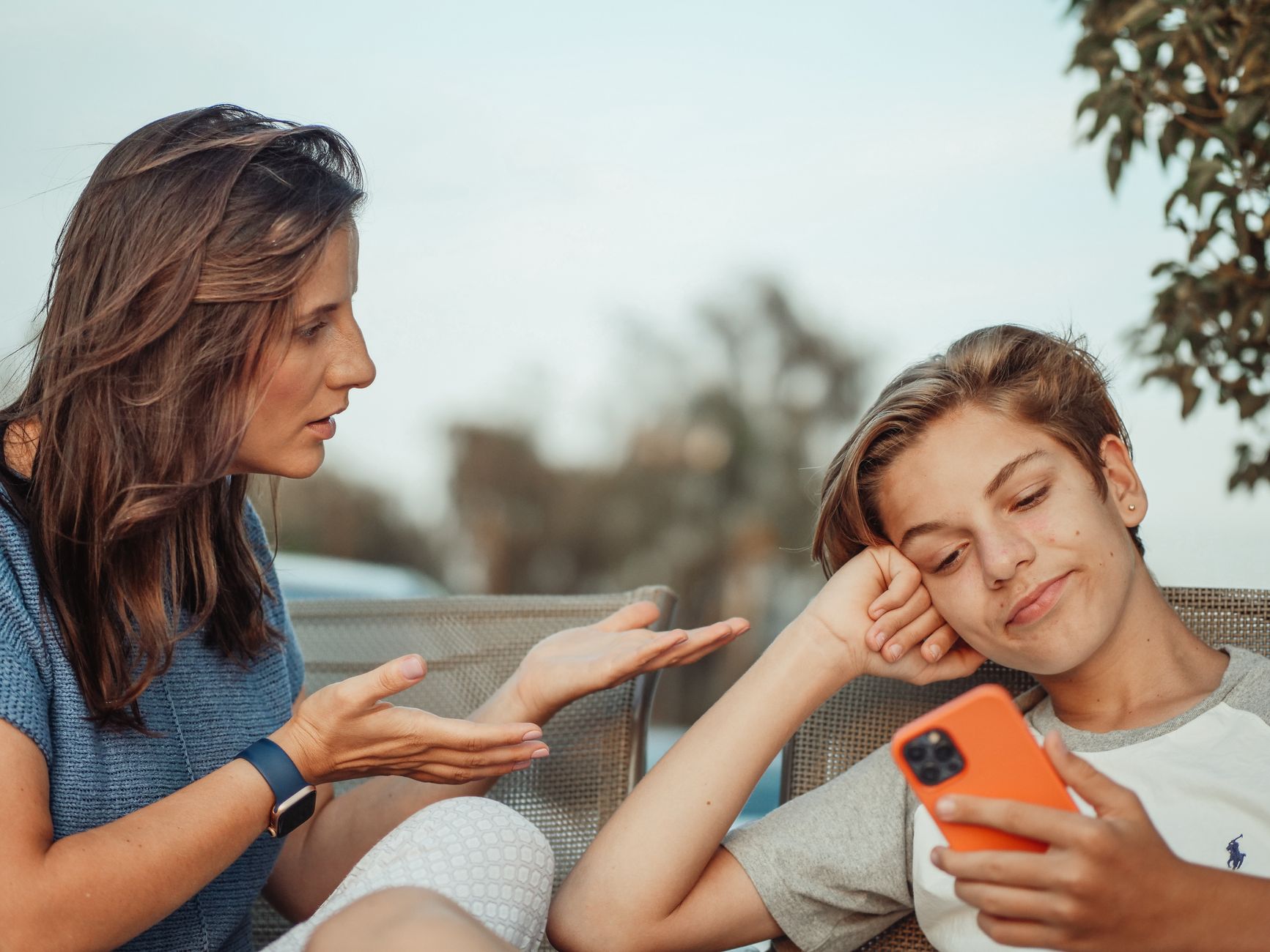 Parent and child discussing digital allowance on a smartphone.