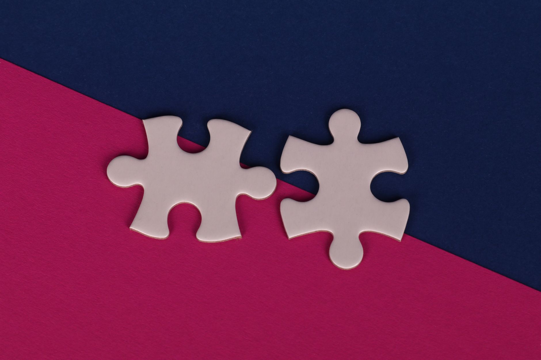 Minimalist illustration of two puzzle pieces representing cooperative parenting.