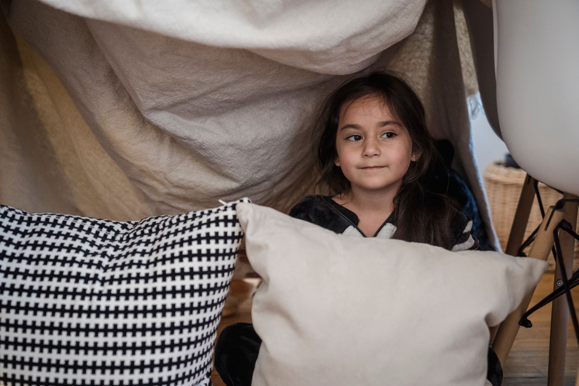 A child building a blanket fort, representing creative and unstructured play at home.