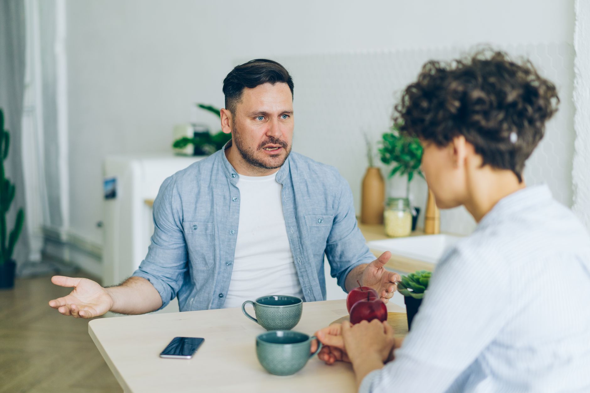 Two adults having a constructive, calm conversation at a table.