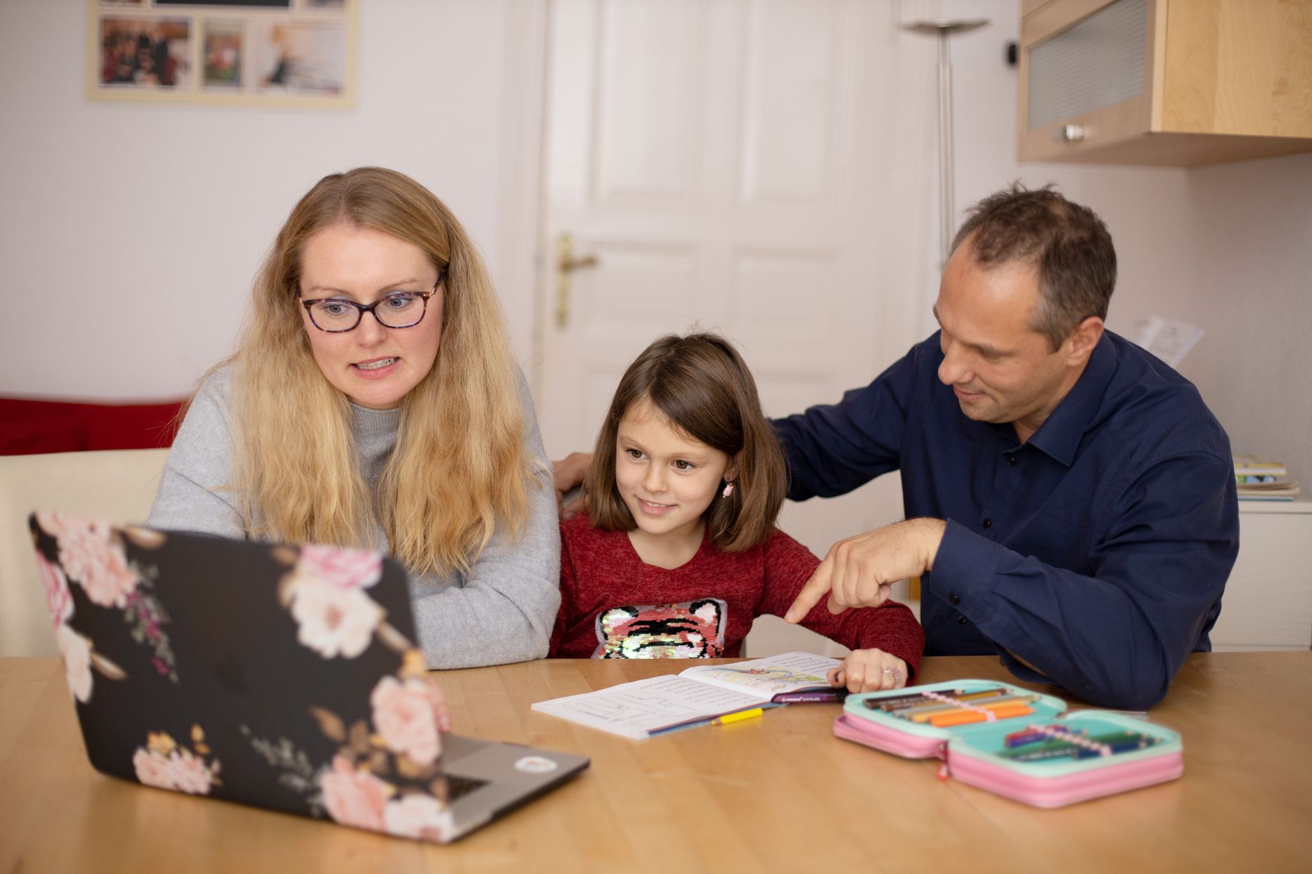 Parent and child collaborating on a digital learning task at home.