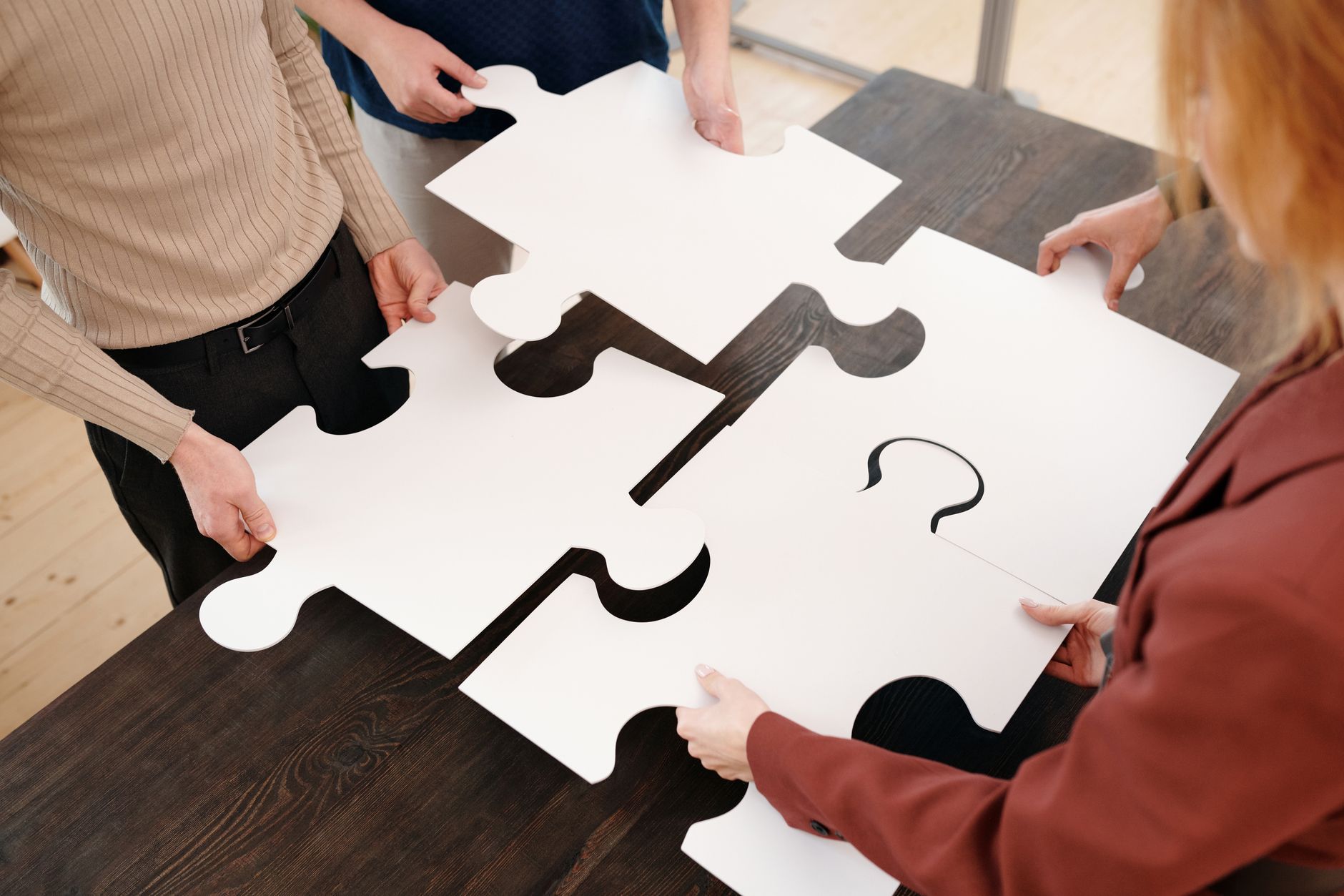 Children's hands working together on a puzzle.