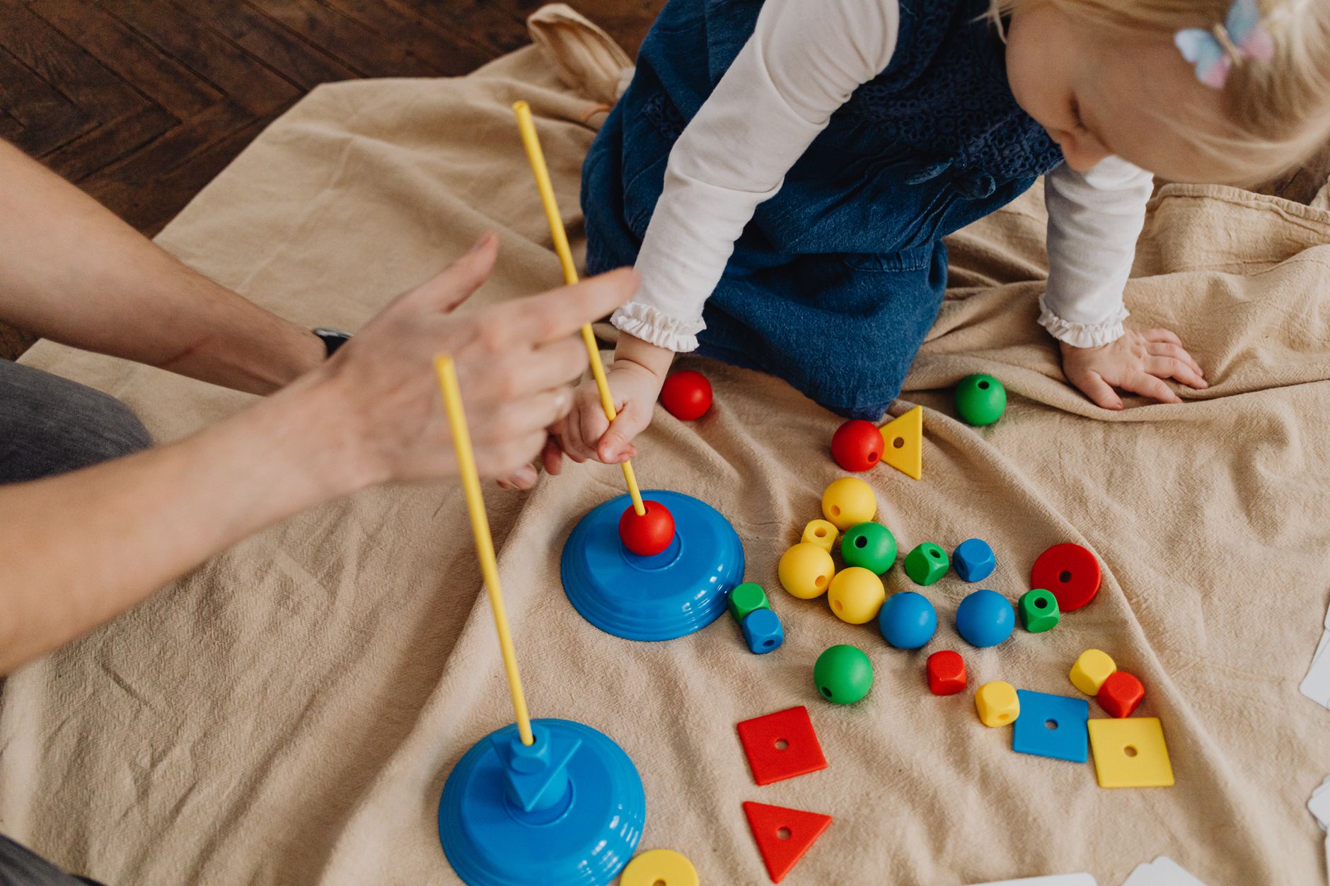 A parent and child engaging in interactive play with language-learning toys.