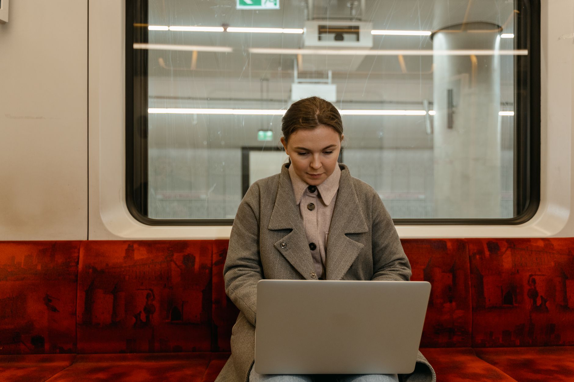 A professional remote worker using a laptop in a public airport lounge.