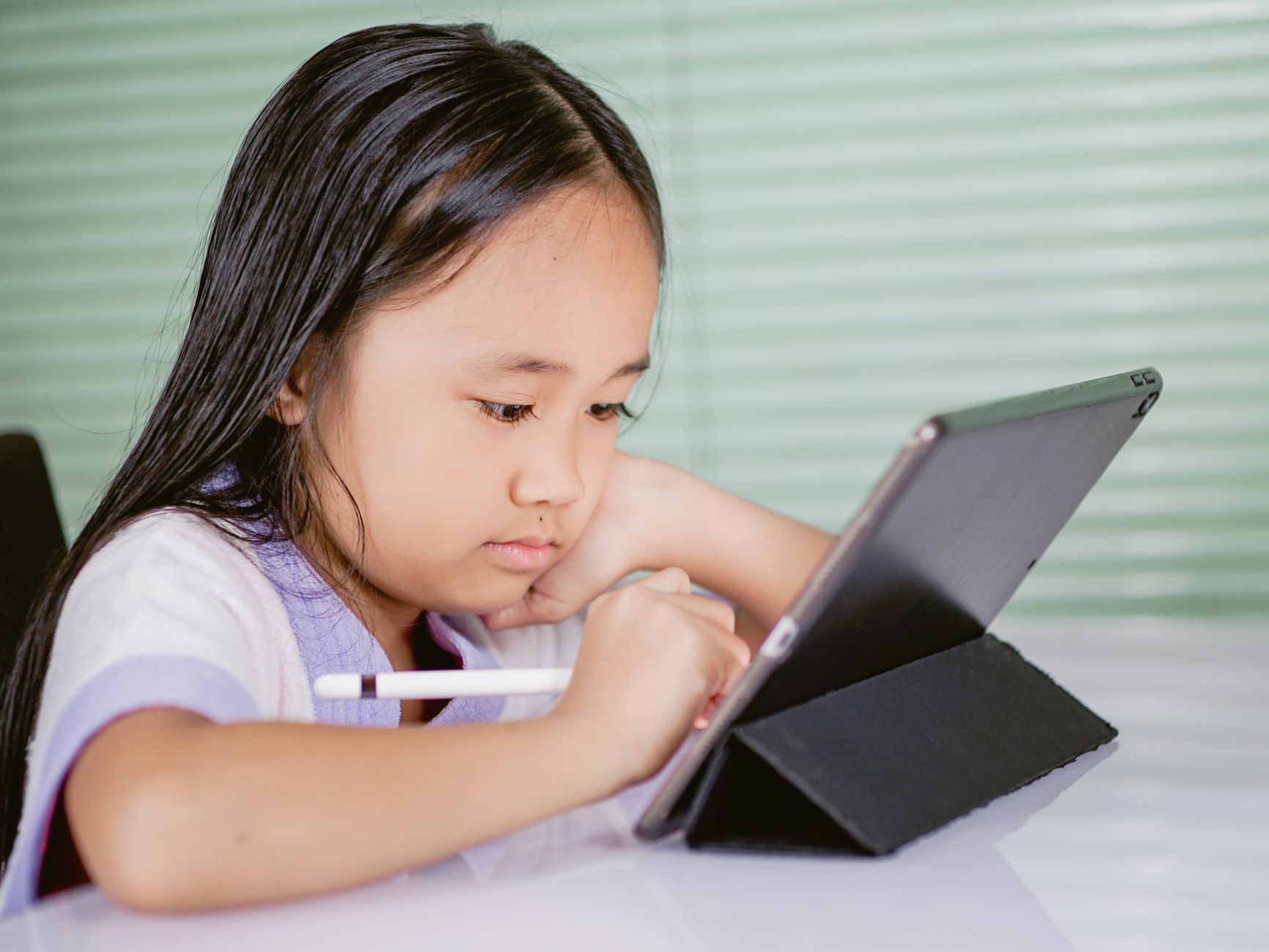 A child using a tablet for language educational software.