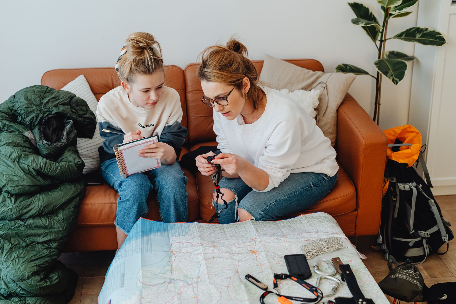 Parent and child using a paper map while hiking.