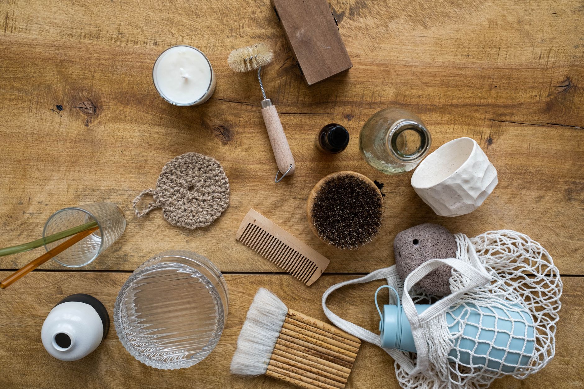 Assorted zero-waste household tools on a wooden surface.