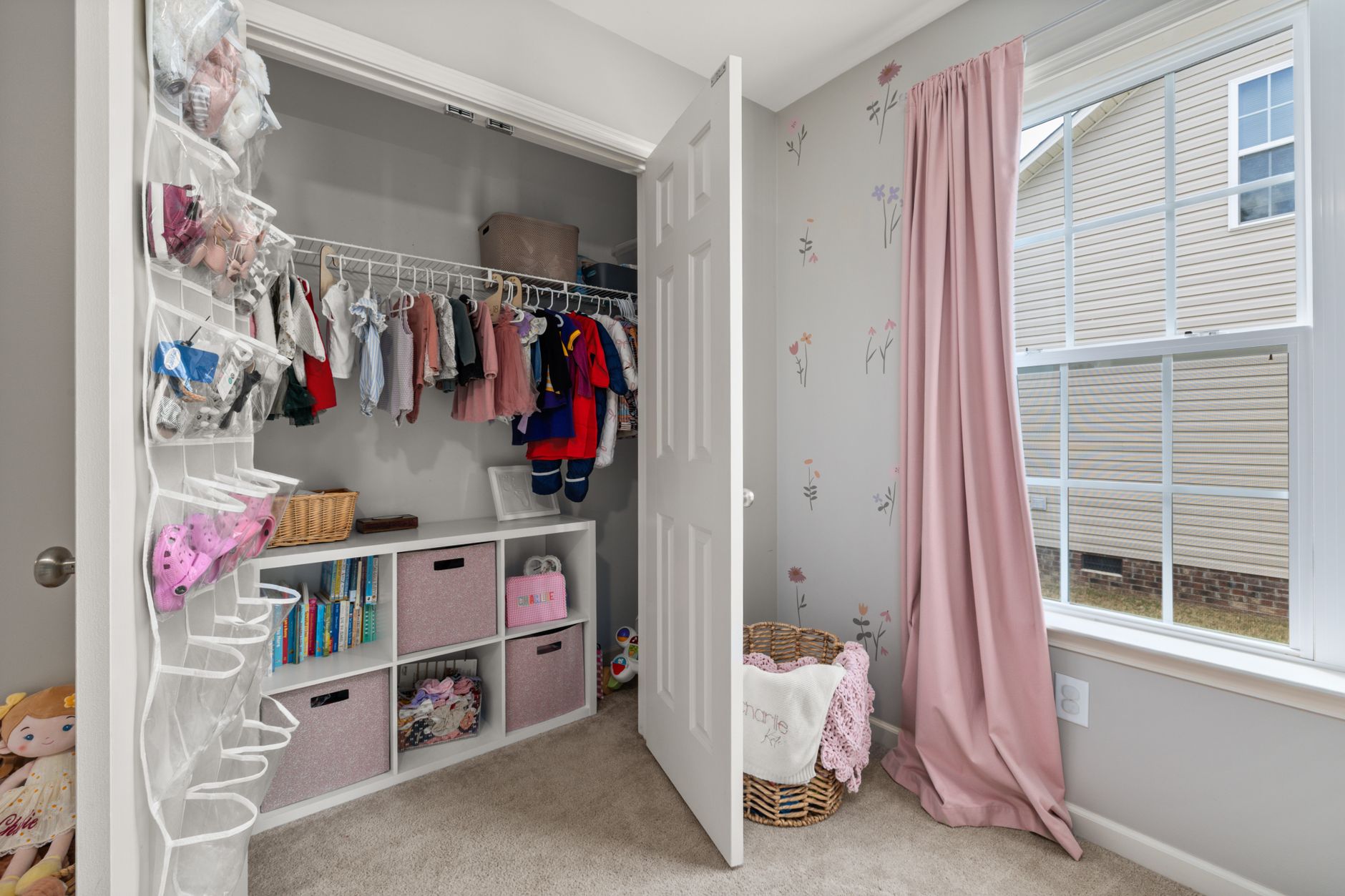 An organized nursery closet with labeled bins for pre-loved clothes.