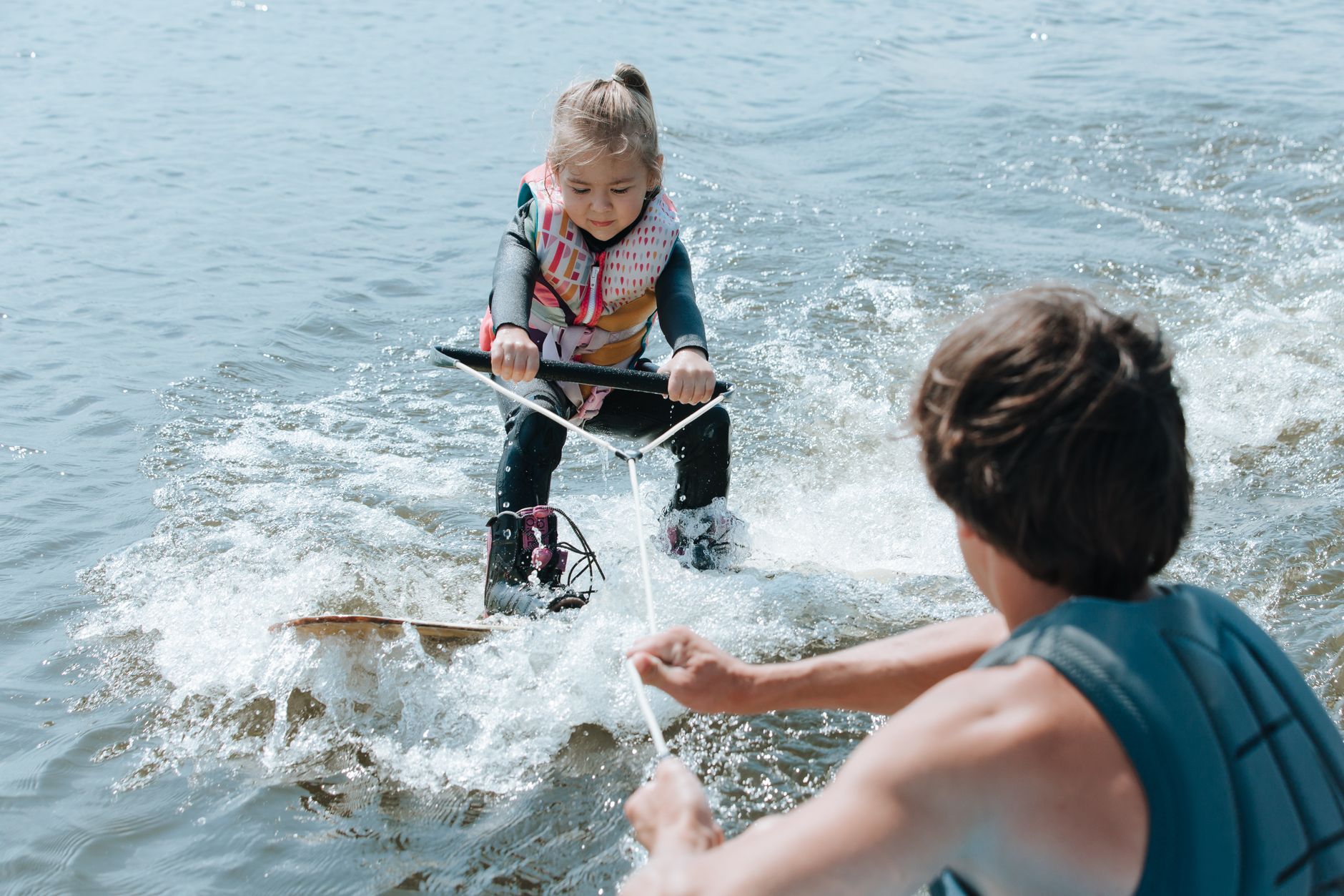 Child learning water sports safely with parental supervision.