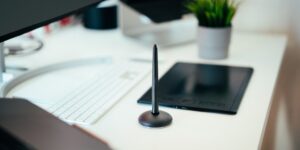 A clean, modern home office desk setup with a tablet displaying a family calendar.