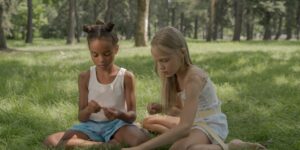 Children playing freely in a park with natural objects, representing the importance of unstructured play.