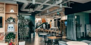 A modern co-working space with an integrated, visible childcare area for working parents.