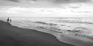 A serene family walking on a quiet beach during the off-season.