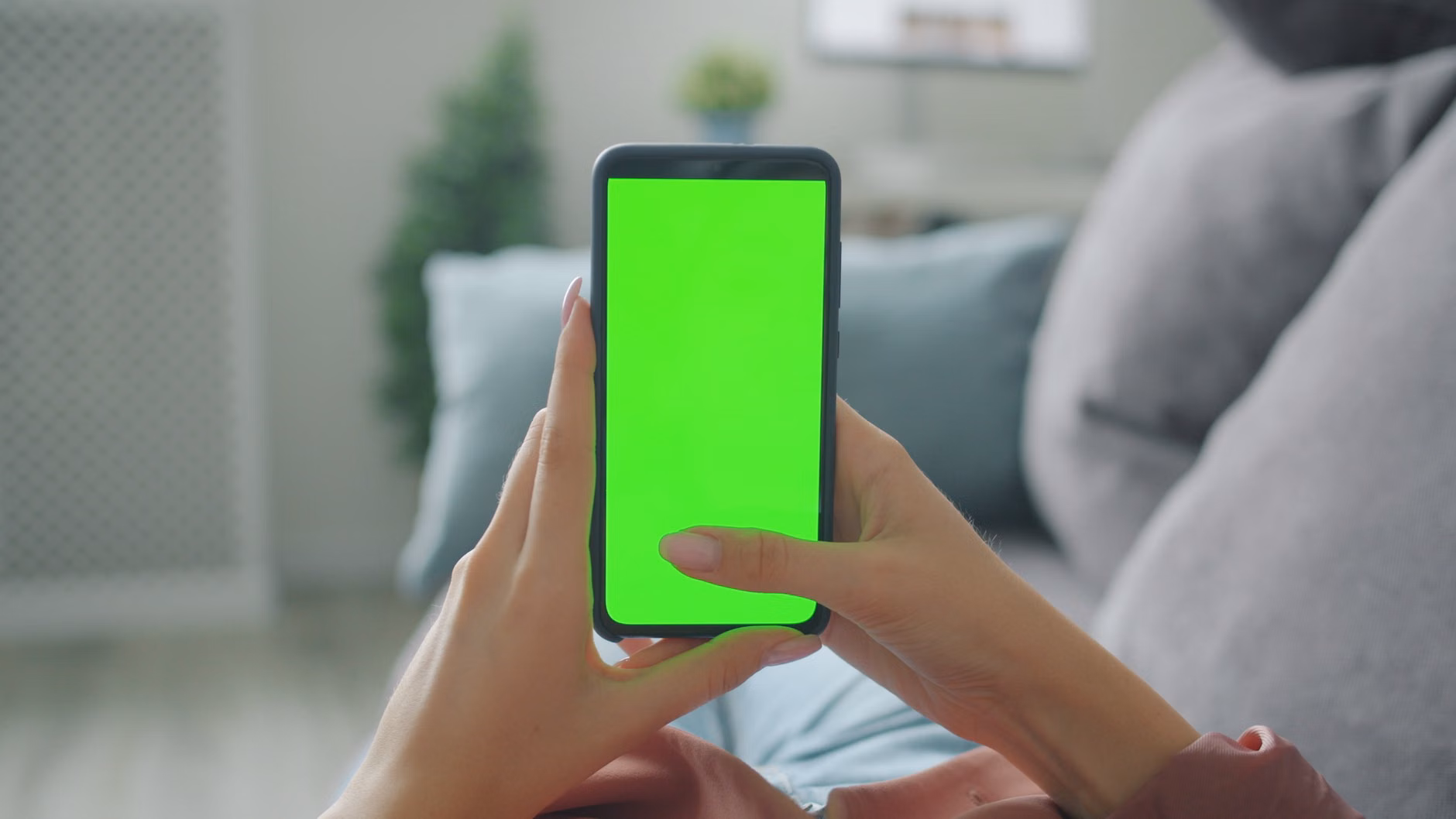 Hands using a drag-and-drop interface on a smartphone for home automation