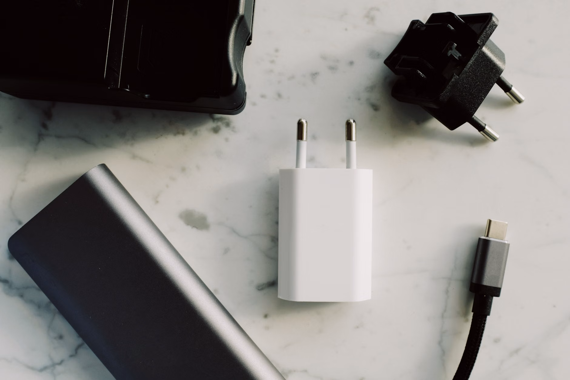 A hand plugging a USB-C cable into various electronic devices.