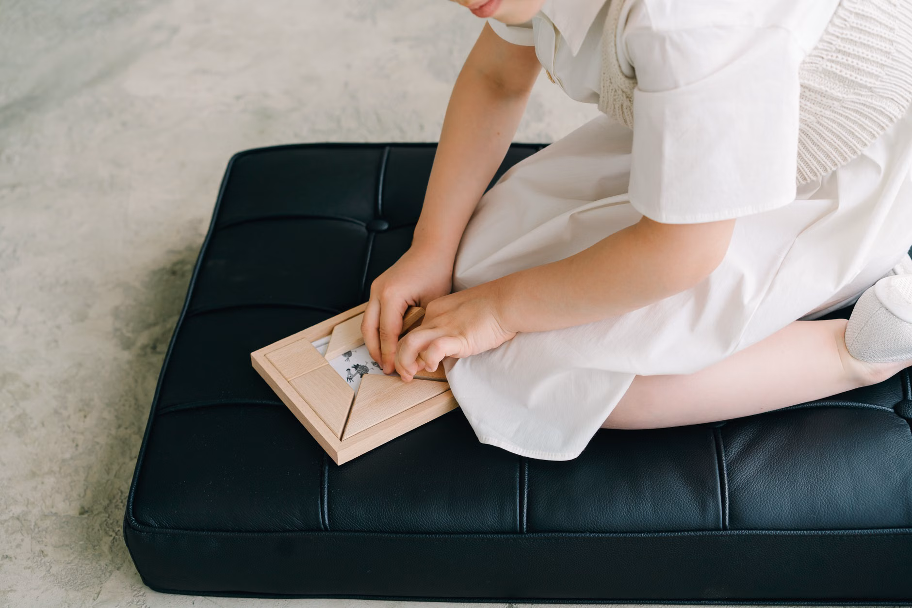 A child engaging in focused play with a wooden puzzle, emphasizing the growth mindset.