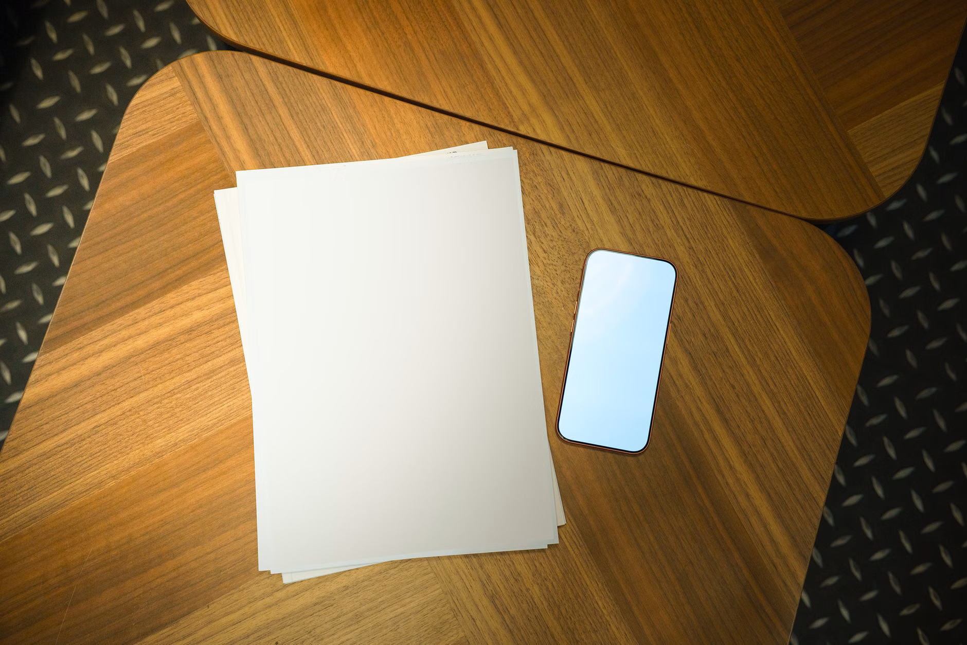 Travel documents and a smartphone on a wooden table representing trip planning.