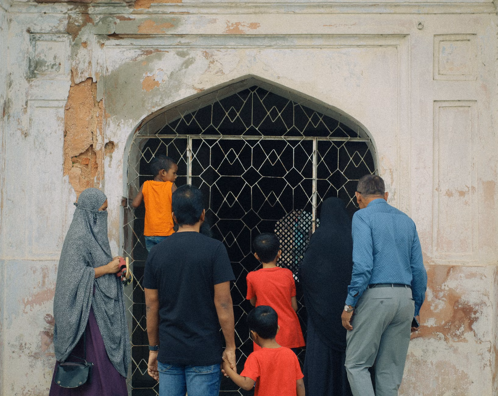 A small group of people observing architectural details on a historic building.