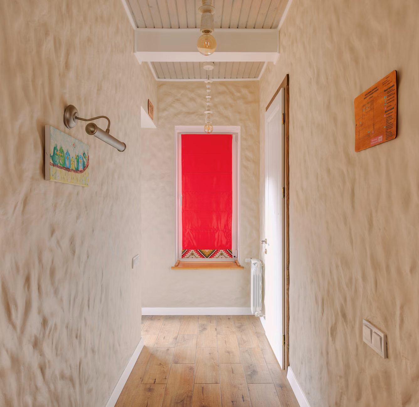 A narrow home climbing wall installed in a hallway with a safety crash pad.