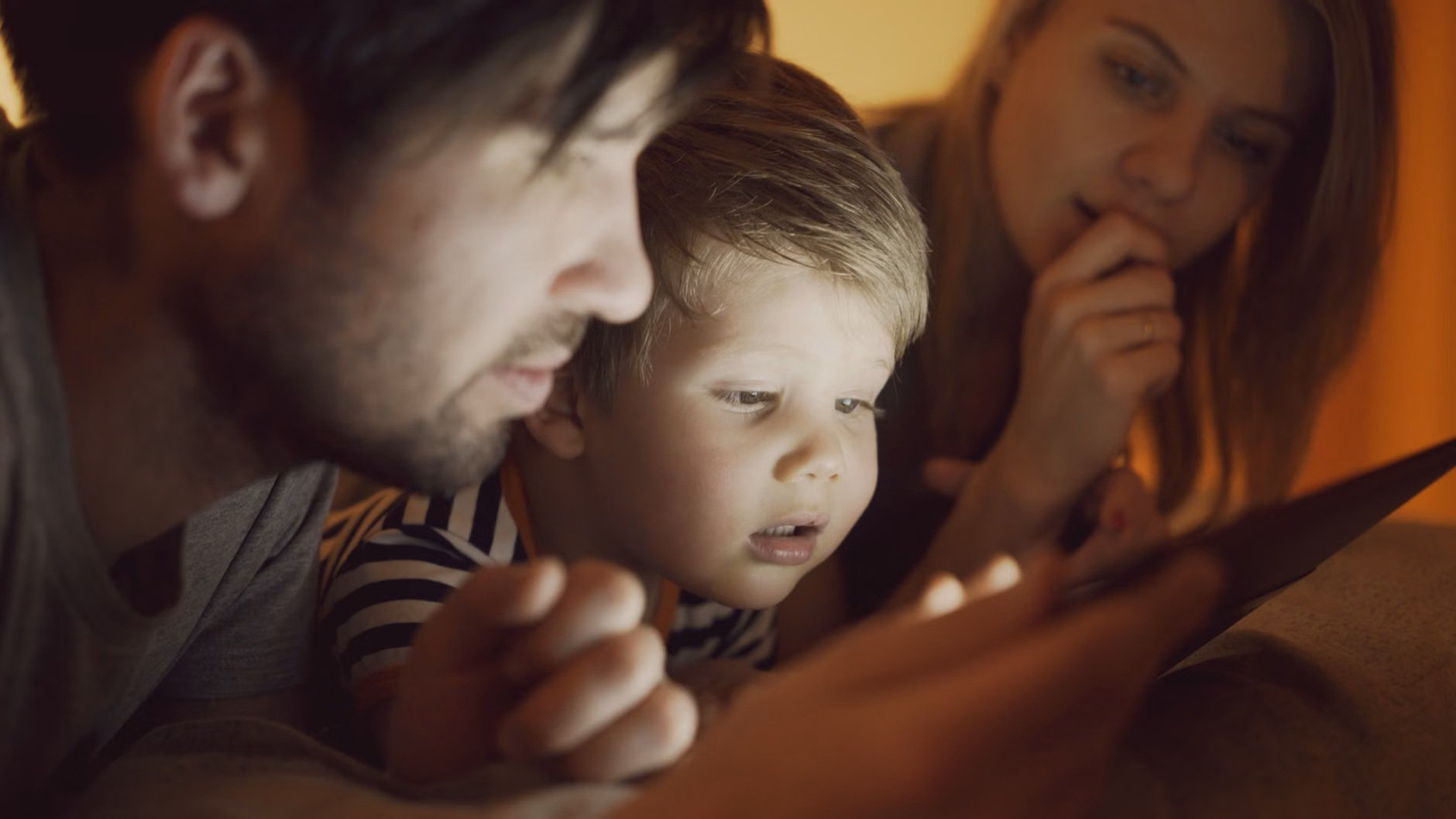 Parent monitoring home security via tablet.