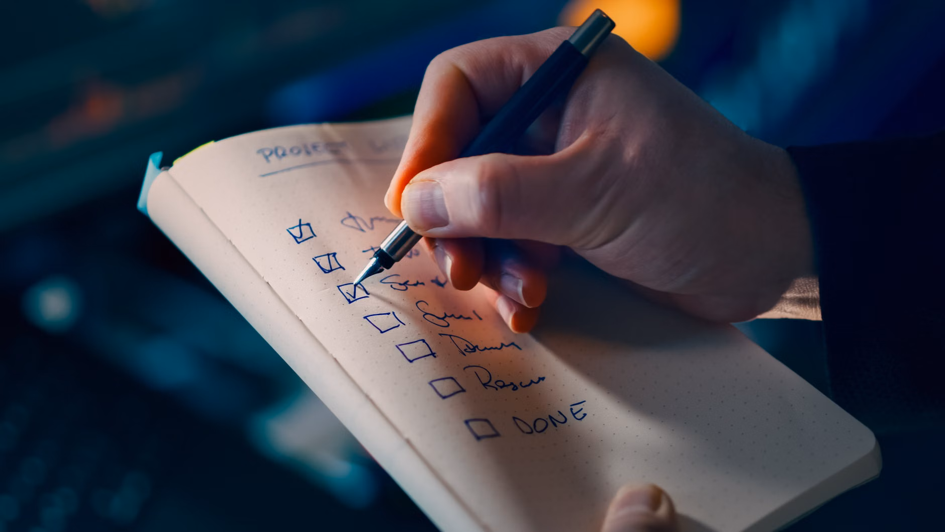A person checking off progress in a notebook.