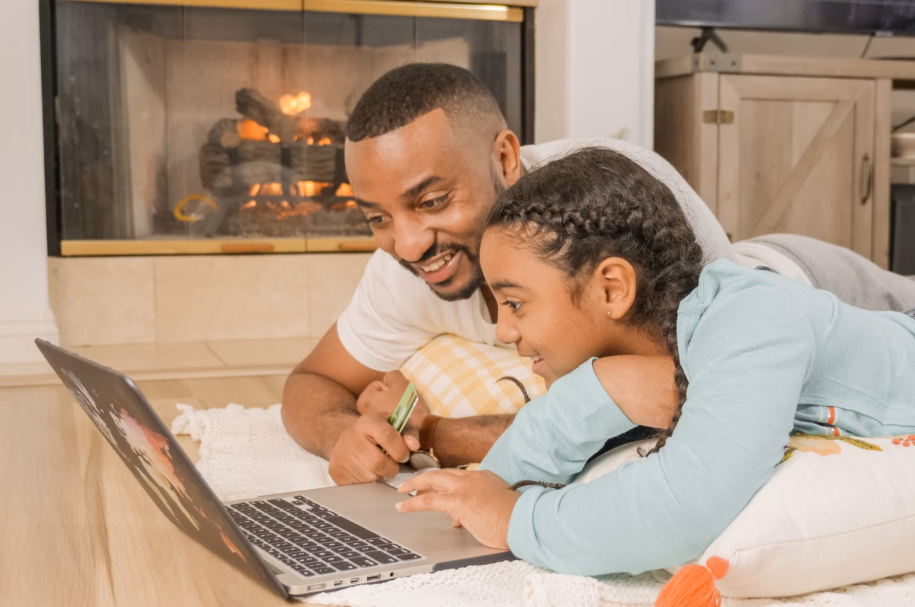 A parent and child browsing the internet together on a computer.