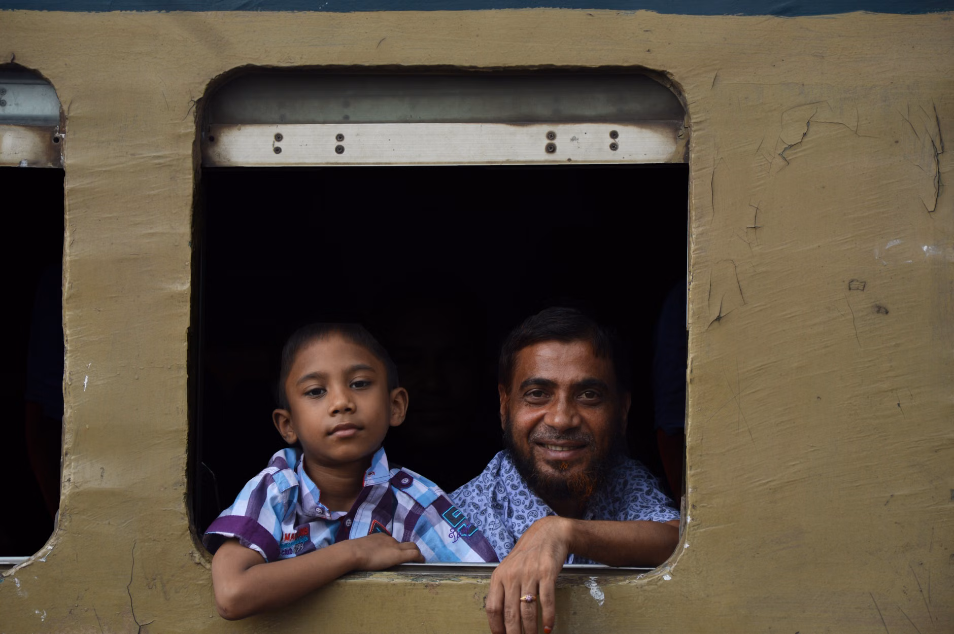 Parent and child enjoying the view from a train window.