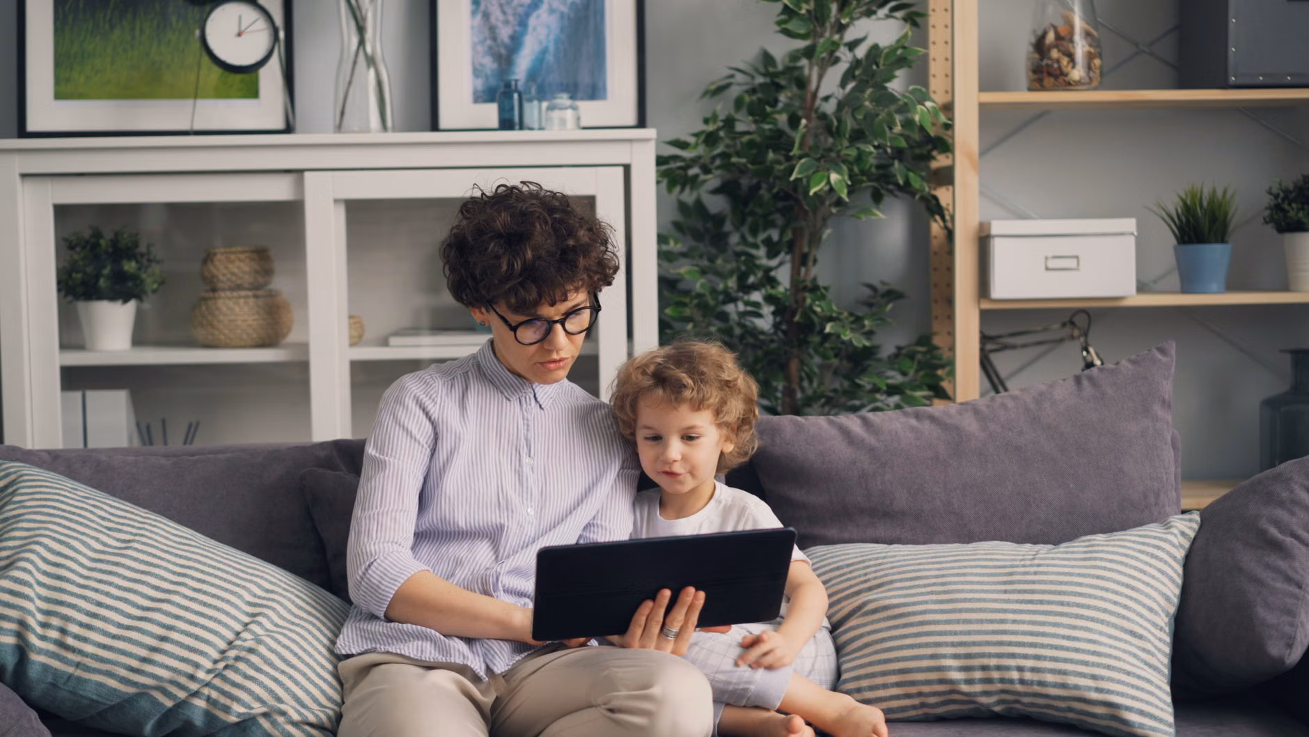 Family monitoring real-time energy consumption on a tablet.
