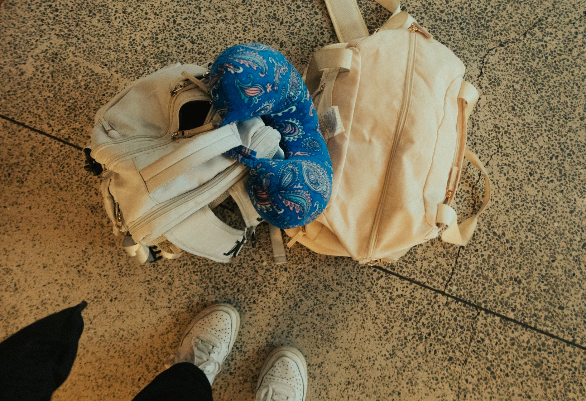 Compact travel gear including a neck pillow and footrest for children.