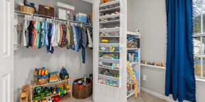 A clean, organized home storage area for children's clothing.