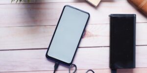 A modern smartphone on a wooden desk representing battery maintenance