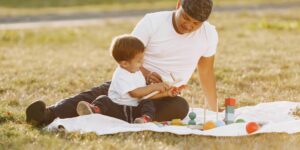 A parent and child resting calmly in a park, representing peaceful family travel.