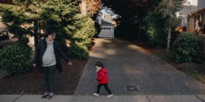 Two parents collaborating in a neighborhood setting to represent the skill-sharing economy.