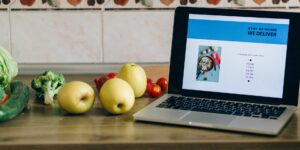 A modern kitchen setting with a delivery app tablet and an hourglass, symbolizing the contrast between speed and patience.