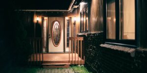A secure, glowing smart doorbell on a porch at sunset.