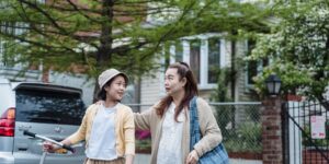 A parent and teenager navigating a city street with a map.