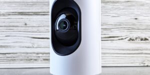 A modern, secure smart home hub sitting on a wooden table in a cozy living room.