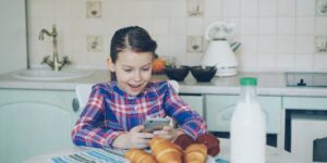 A smartphone on a kitchen table representing the digital distractions of parenthood.