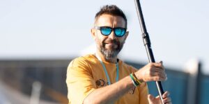 A middle-aged person learning a new sport on a sunny court.
