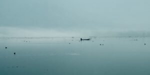 A peaceful, misty lake scene representing the Quiet Travel movement.