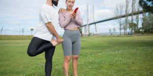 A couple looking at a fitness app on their phone in a modern living room