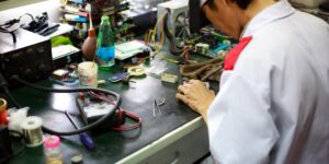 A clean, professional home electronics repair workbench with tools and an open device.