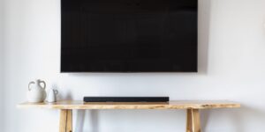 A sleek E-Ink digital calendar mounted on a wall in a modern family living room.
