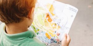 A family using a paper map in an urban park for a scavenger hunt.