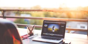 A closed laptop on a desk at sunset, representing the end of the workday.