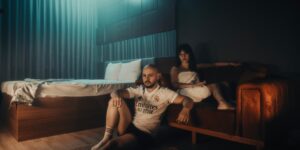A couple sitting on a sofa in a dim, cozy living room reflecting on their day.