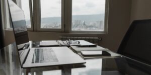 A laptop on a desk with a scenic view, representing remote work travel.